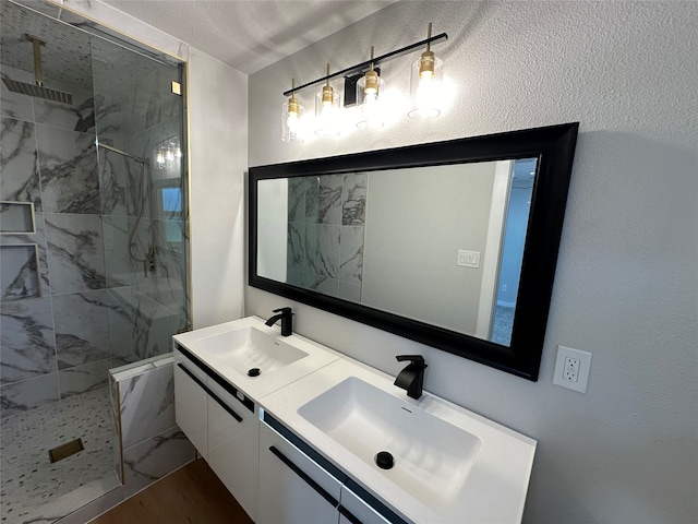 bathroom featuring vanity, wood-type flooring, and tiled shower