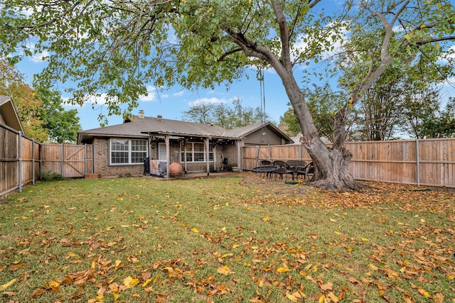 rear view of house with a patio and a lawn