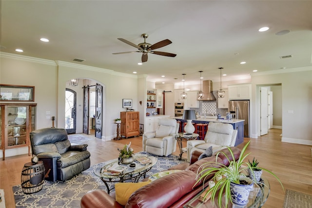 living room featuring light hardwood / wood-style flooring, ceiling fan, and crown molding