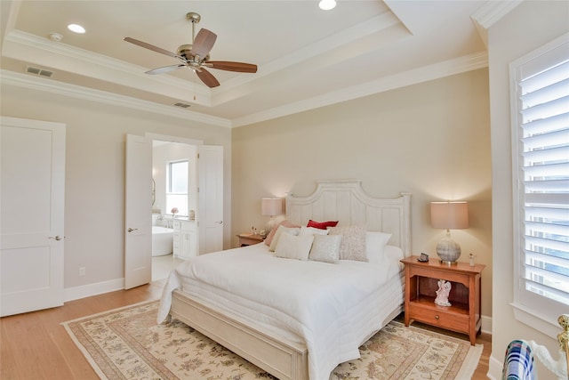 bedroom with connected bathroom, ceiling fan, multiple windows, and light hardwood / wood-style flooring