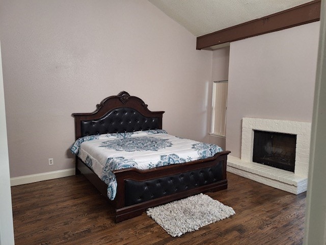 bedroom featuring dark hardwood / wood-style flooring, vaulted ceiling, and a textured ceiling