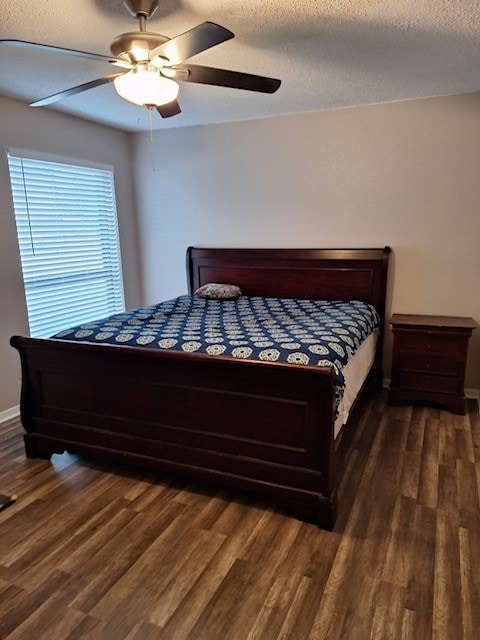 bedroom with a textured ceiling, ceiling fan, and dark hardwood / wood-style floors