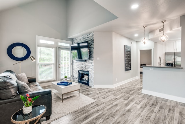 living room with light wood-type flooring and a fireplace