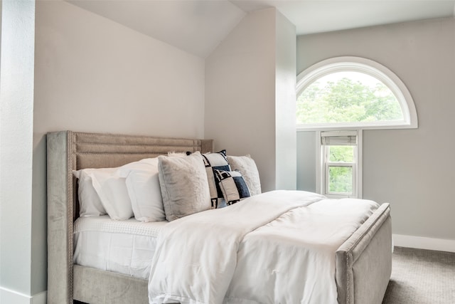 carpeted bedroom with lofted ceiling