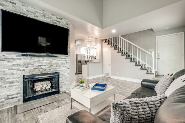 living room featuring hardwood / wood-style floors and a stone fireplace