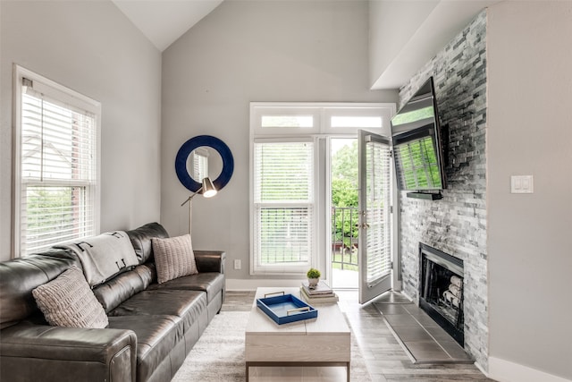 living room with vaulted ceiling, a fireplace, and hardwood / wood-style flooring