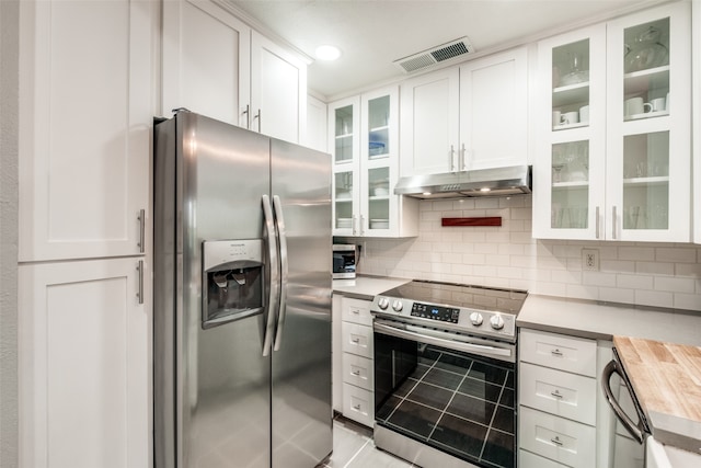 kitchen with butcher block counters, white cabinets, stainless steel appliances, and tasteful backsplash