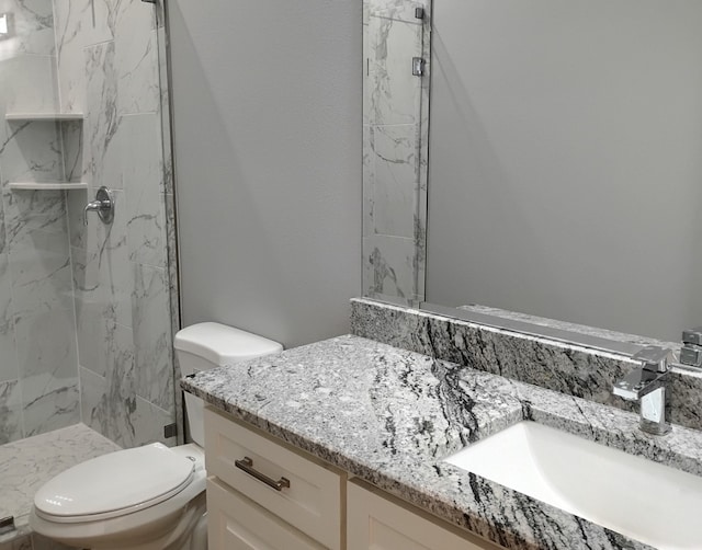 bathroom with vanity, toilet, and a shower with shower door