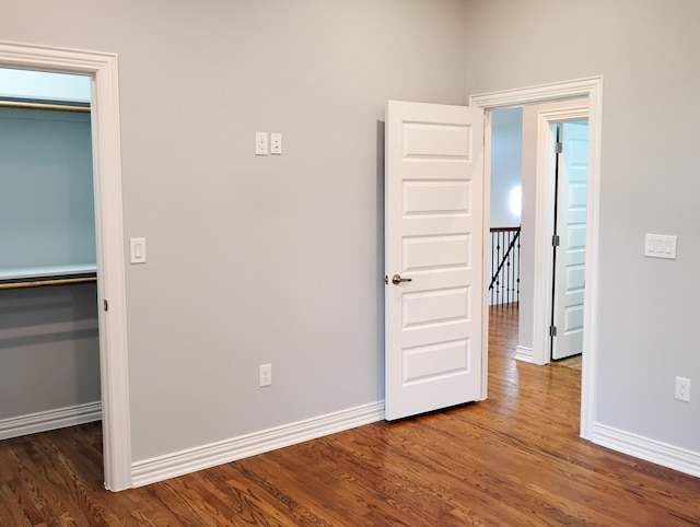 unfurnished bedroom featuring a closet and dark wood-type flooring