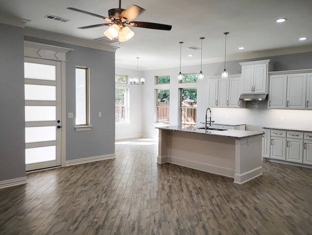 kitchen with ornamental molding, sink, a center island with sink, dark hardwood / wood-style floors, and white cabinetry