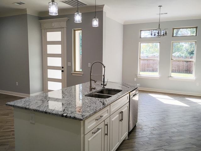 kitchen with a center island with sink, decorative light fixtures, stainless steel dishwasher, and sink