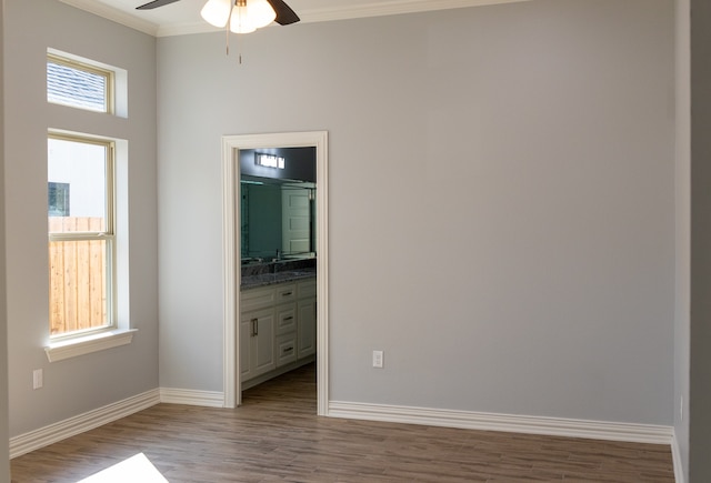 unfurnished bedroom featuring light hardwood / wood-style flooring, ensuite bath, ceiling fan, and crown molding