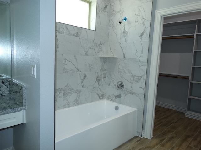 bathroom featuring vanity, wood-type flooring, and tiled shower / bath combo