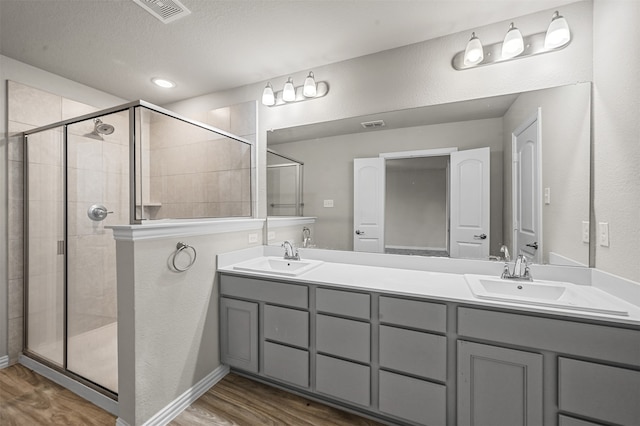 bathroom featuring vanity, walk in shower, a textured ceiling, and hardwood / wood-style floors