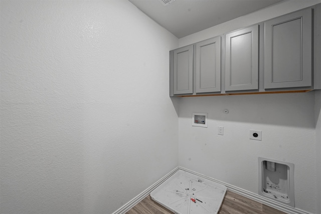 clothes washing area featuring hookup for a gas dryer, electric dryer hookup, washer hookup, dark hardwood / wood-style floors, and cabinets