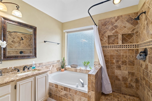 bathroom with vanity and shower with separate bathtub