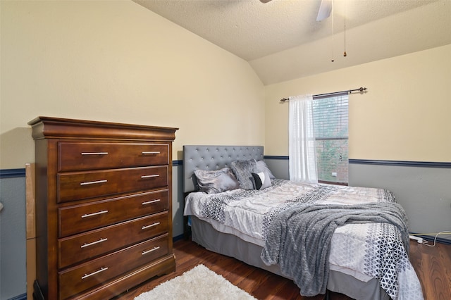 bedroom featuring dark hardwood / wood-style flooring, a textured ceiling, ceiling fan, and vaulted ceiling