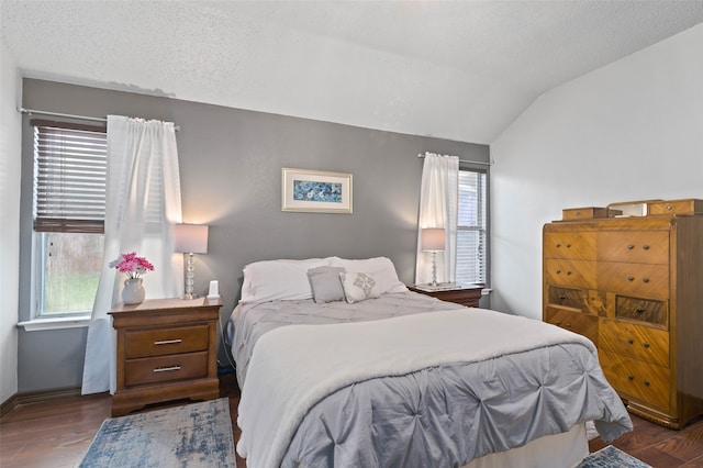 bedroom with a textured ceiling, lofted ceiling, and dark hardwood / wood-style flooring