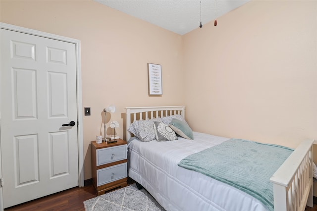 bedroom featuring a textured ceiling and dark wood-type flooring