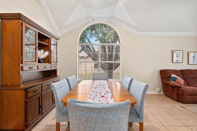 tiled dining room with lofted ceiling and ornamental molding