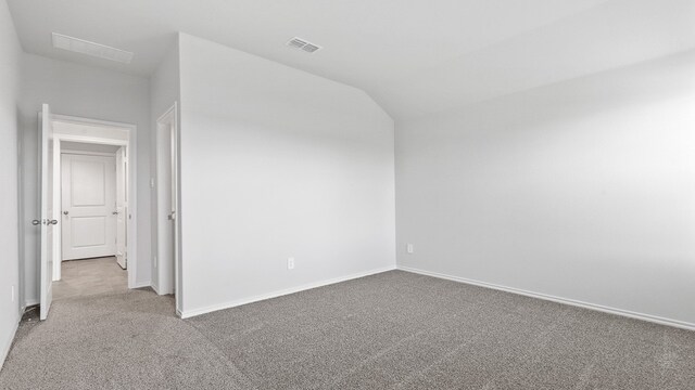 spare room with lofted ceiling and carpet flooring