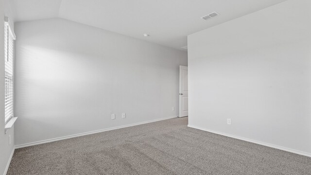 carpeted spare room with lofted ceiling