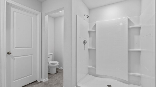 bathroom with a shower and toilet