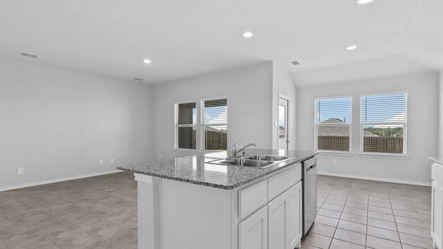 kitchen with stone countertops, an island with sink, sink, stainless steel dishwasher, and white cabinets