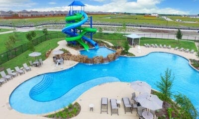 view of swimming pool featuring a water slide, a playground, and a patio