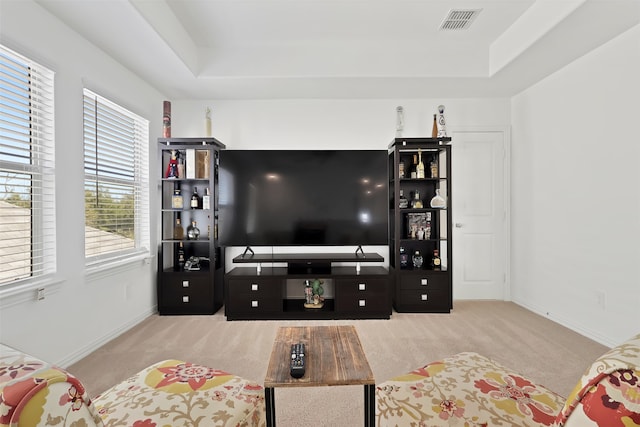 carpeted living room featuring a tray ceiling