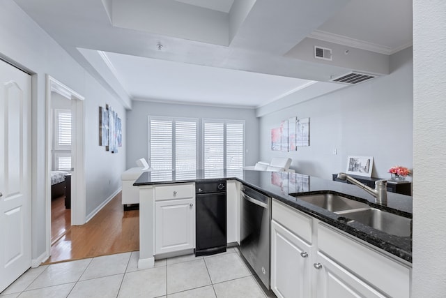 kitchen with a healthy amount of sunlight, dishwasher, kitchen peninsula, and white cabinets