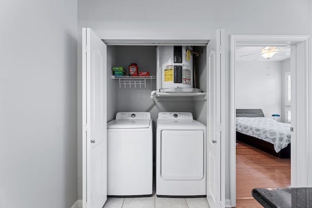 laundry room featuring light hardwood / wood-style flooring, water heater, washing machine and clothes dryer, and ceiling fan