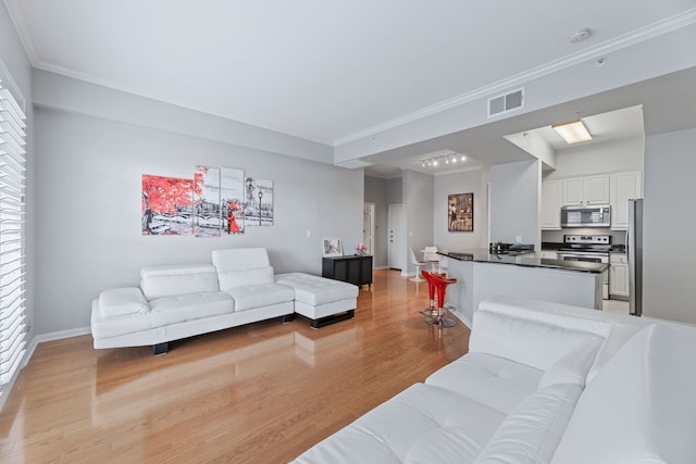 living room with ornamental molding and light hardwood / wood-style flooring