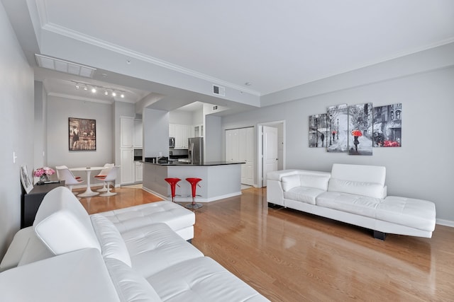 living room with light hardwood / wood-style flooring and ornamental molding