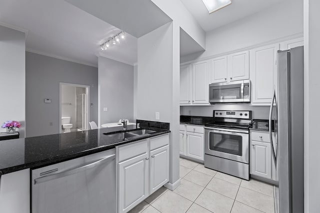 kitchen featuring light tile patterned floors, appliances with stainless steel finishes, white cabinetry, crown molding, and sink