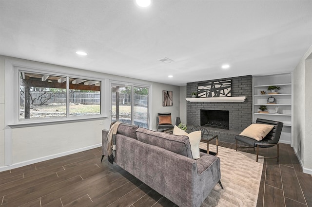 living room featuring dark hardwood / wood-style flooring and a brick fireplace