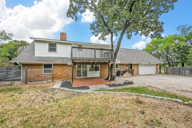 front of property with a front yard, central AC, a wooden deck, and a garage