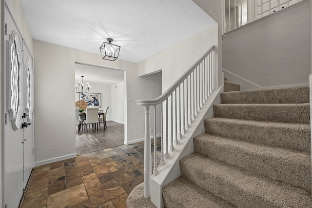 entryway featuring an inviting chandelier and dark wood-type flooring