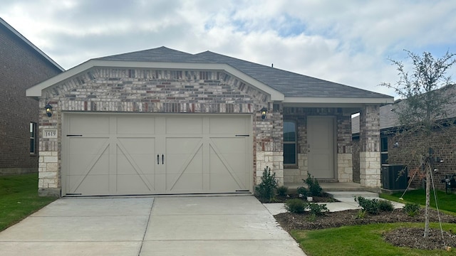 view of front of home with central AC unit and a garage