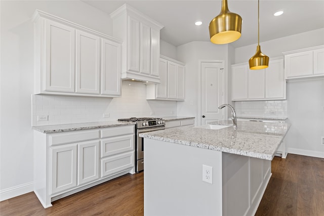 kitchen featuring stainless steel gas range oven, sink, decorative light fixtures, dark hardwood / wood-style floors, and white cabinetry