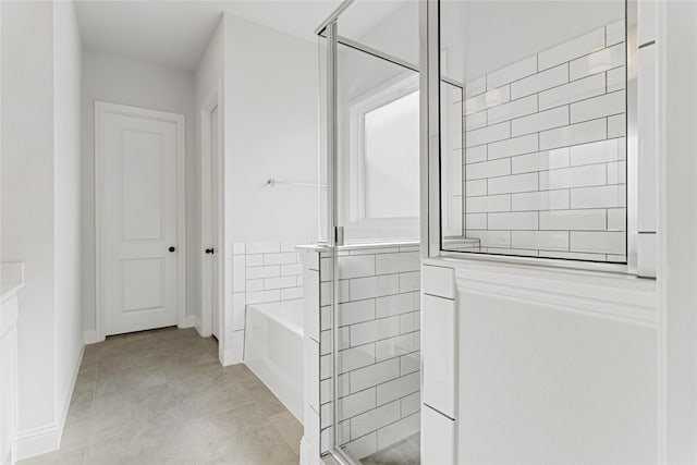 bathroom featuring tile patterned flooring, tile walls, and independent shower and bath