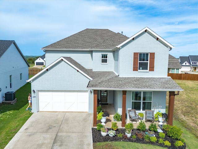 front of property with central AC, a front lawn, and a garage