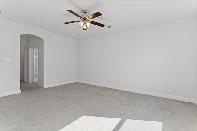 spare room with ceiling fan and light colored carpet