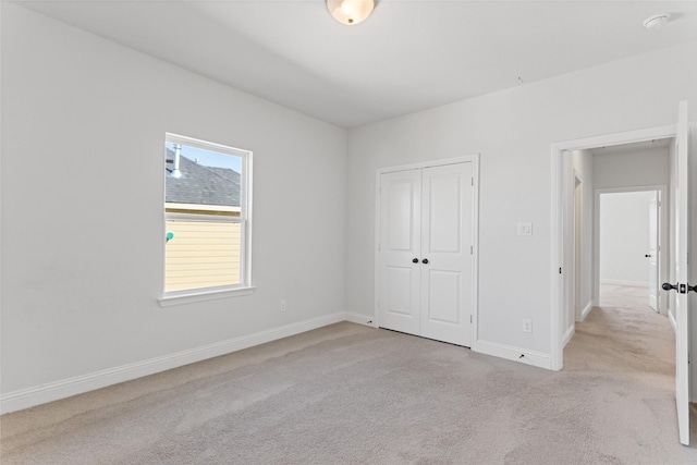 unfurnished bedroom featuring light carpet and a closet