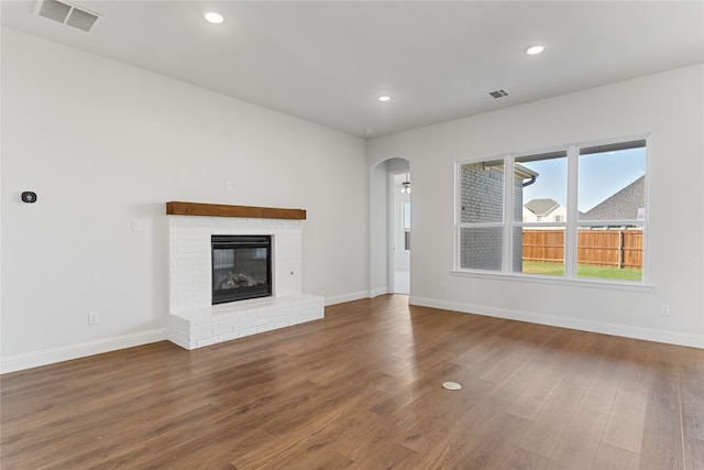 unfurnished living room featuring a fireplace and hardwood / wood-style flooring