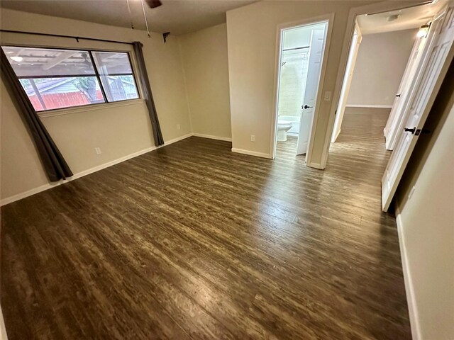 806 Mckinney Ave, Princeton, TX 75407 - unfurnished bedroom featuring baseboards, ensuite bath, and dark wood-style floors