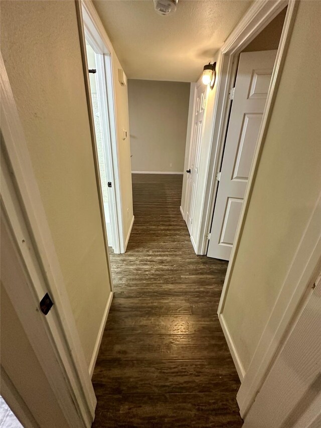 806 Mckinney Ave, Princeton, TX 75407 - hall featuring baseboards, a textured ceiling, and dark wood-style floors