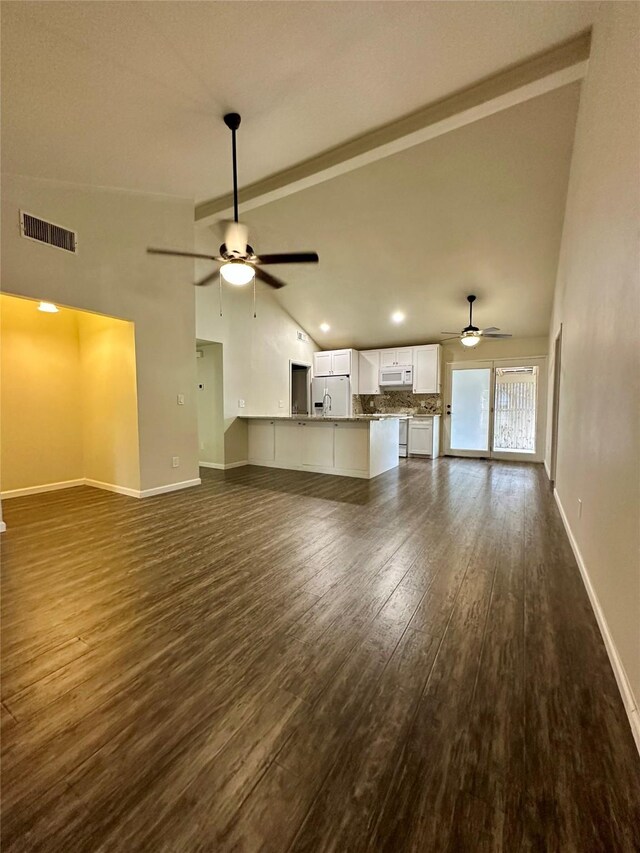 806 Mckinney Ave, Princeton, TX 75407 - unfurnished living room with visible vents, dark wood-style flooring, baseboards, ceiling fan, and high vaulted ceiling
