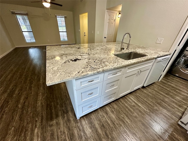 kitchen with light stone countertops, sink, white cabinetry, and dark hardwood / wood-style flooring