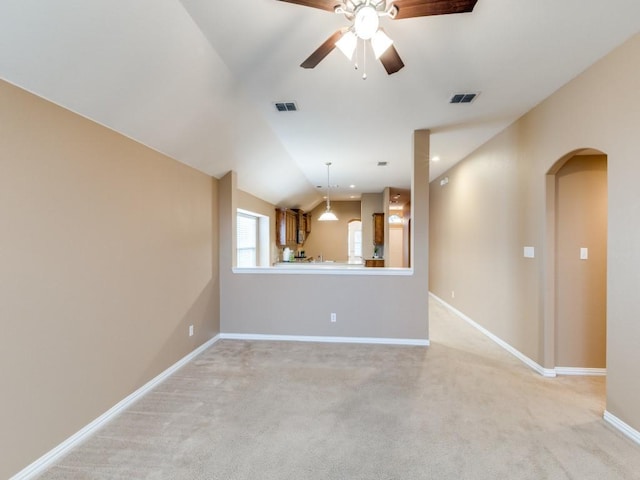 empty room with visible vents, ceiling fan, light carpet, and arched walkways